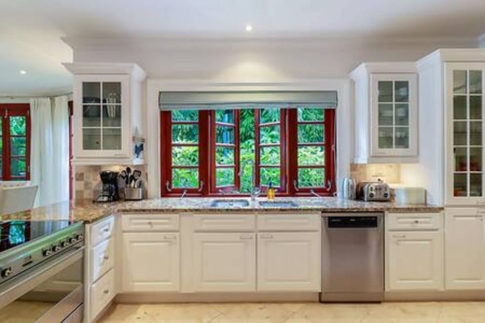 Open plan kitchen with blender, breakfast bar, coffee maker, dishwasher, electric hob, juicer, kettle, microwave, oven, toaster, tumble dryer, washing machine and a wine fridge.