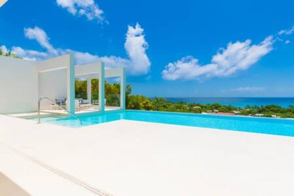 Beautiful private infinity pool with sun loungers, sun umbrellas, garden sofas and a fabulous sea view.