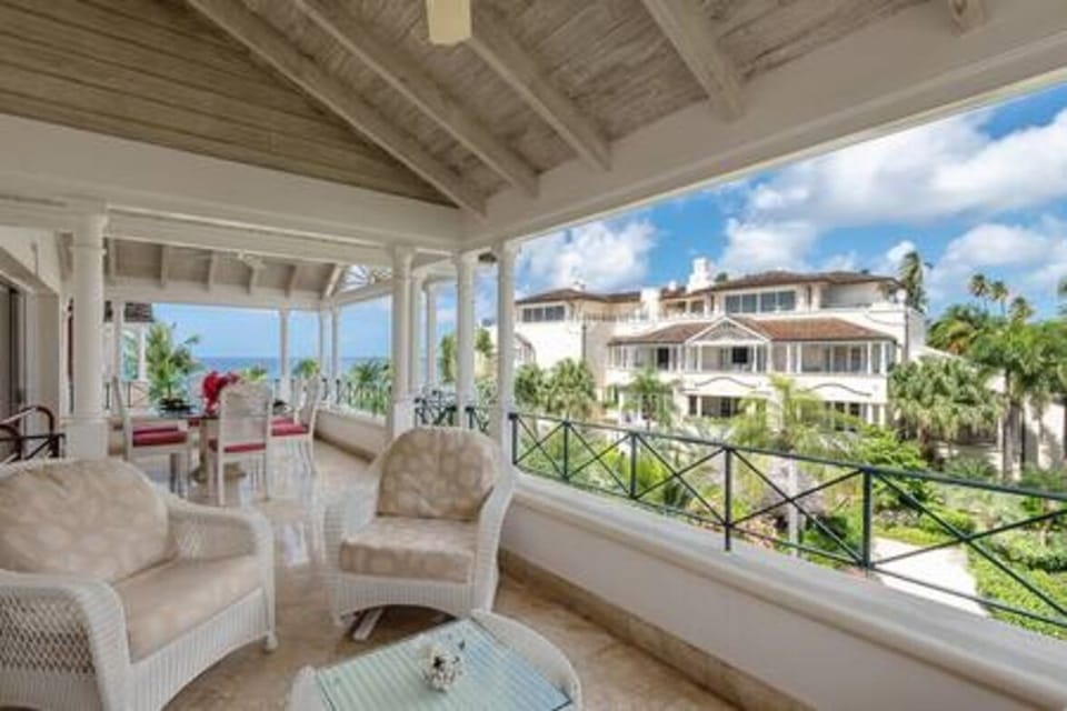 Spacious balcony area with seating and views over the communal gardens and sea.