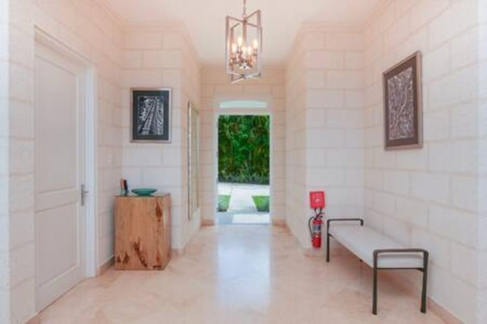 Stylish open plan living room with comfortable sofas , flat screen TV and ceiling fans.