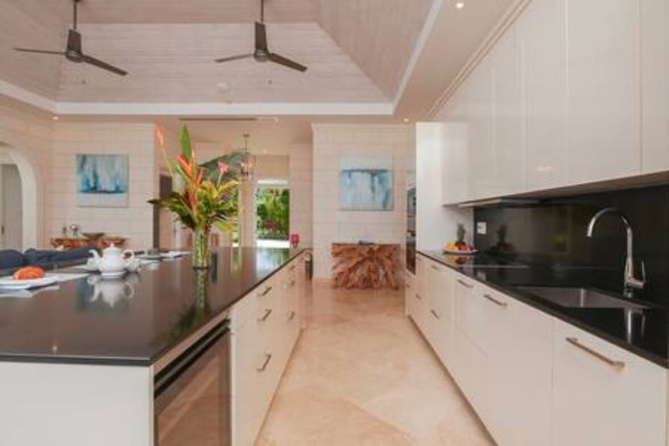 Open plan modern kitchen with wine fridge, electric hob, oven, fridge freezer, coffee machine, dishwasher, food processor, ice maker, kettle, microwave, toaster, washing machine and tumble dryer.