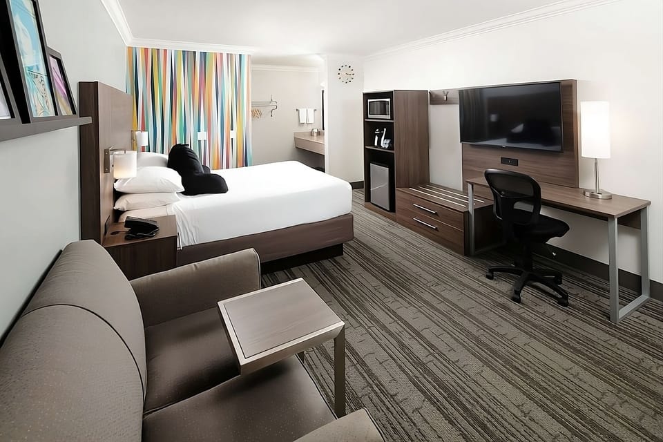 Relax in a bright king room with sofa and workspace.