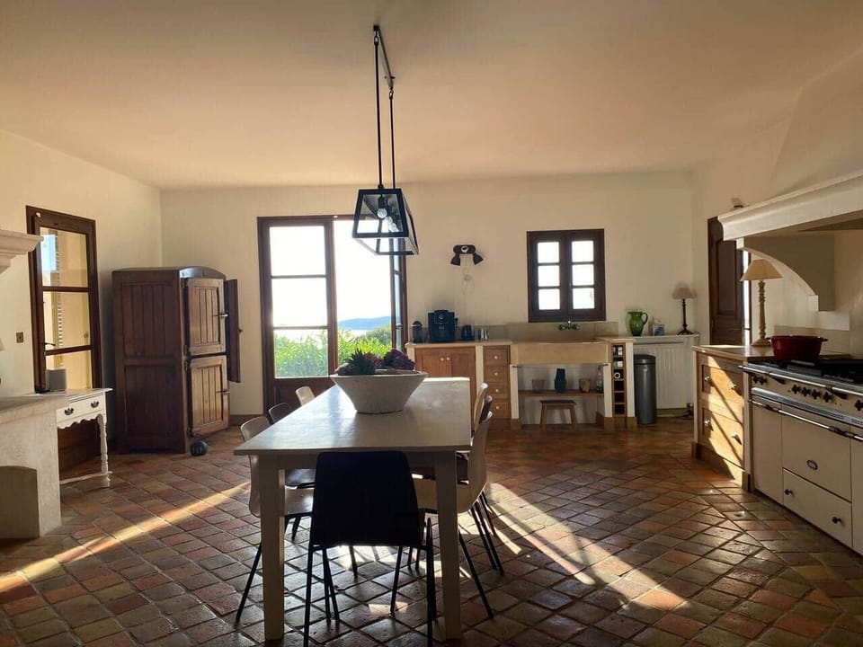 Cuisine avec cheminée, espace repas et piano Lacanche sur mer