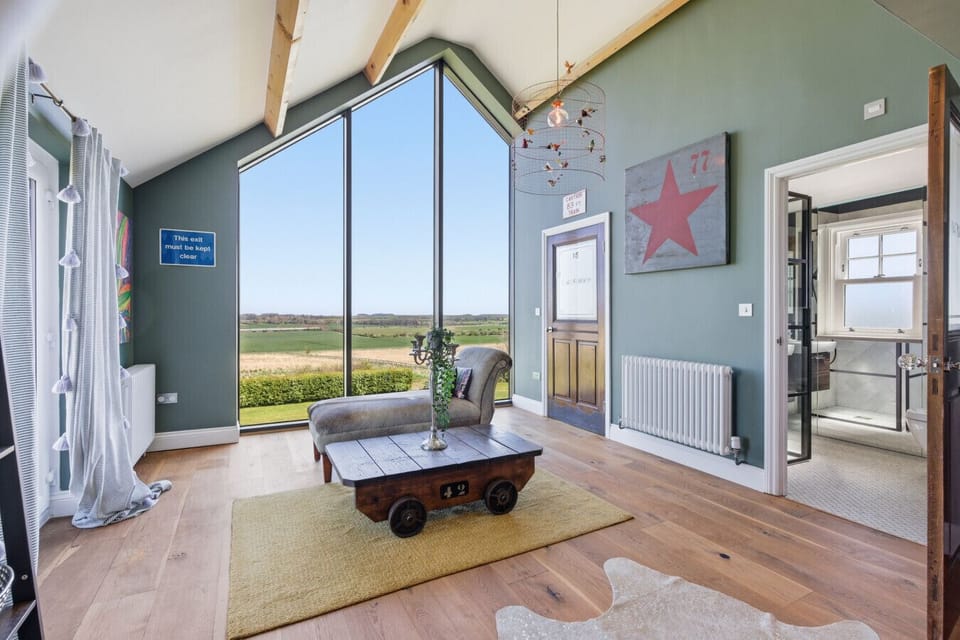Cathedral-style window framing panoramic Northumberland countryside views.