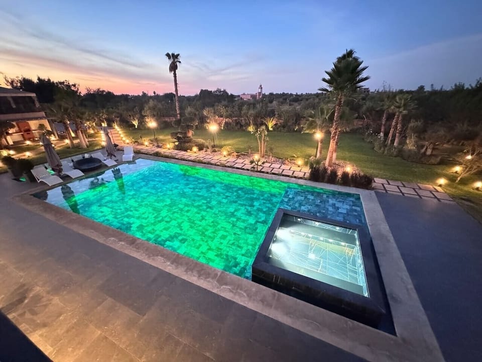 Grande piscine privée au cœur du jardin, parfaite pour des journées ensoleillées et des moments de détente.