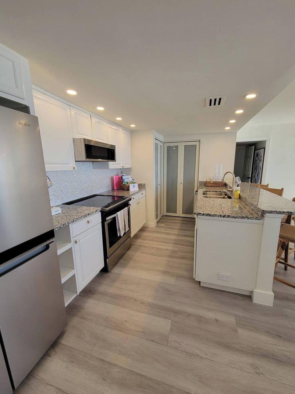 Your spacious kitchen features white cabinetry, gleaming granite countertops, and modern black appliances—perfect for preparing meals in style during your stay.
