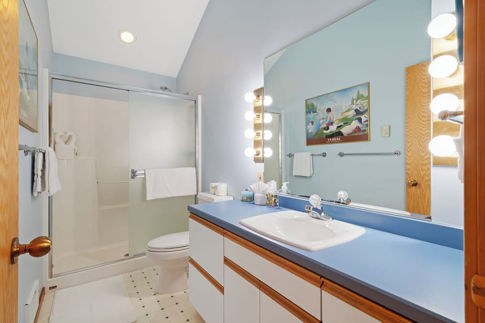Step into your private retreat with a spacious vanity, modern fixtures, and bright lighting framing the mirror—perfect for unwinding after a day of adventure.
