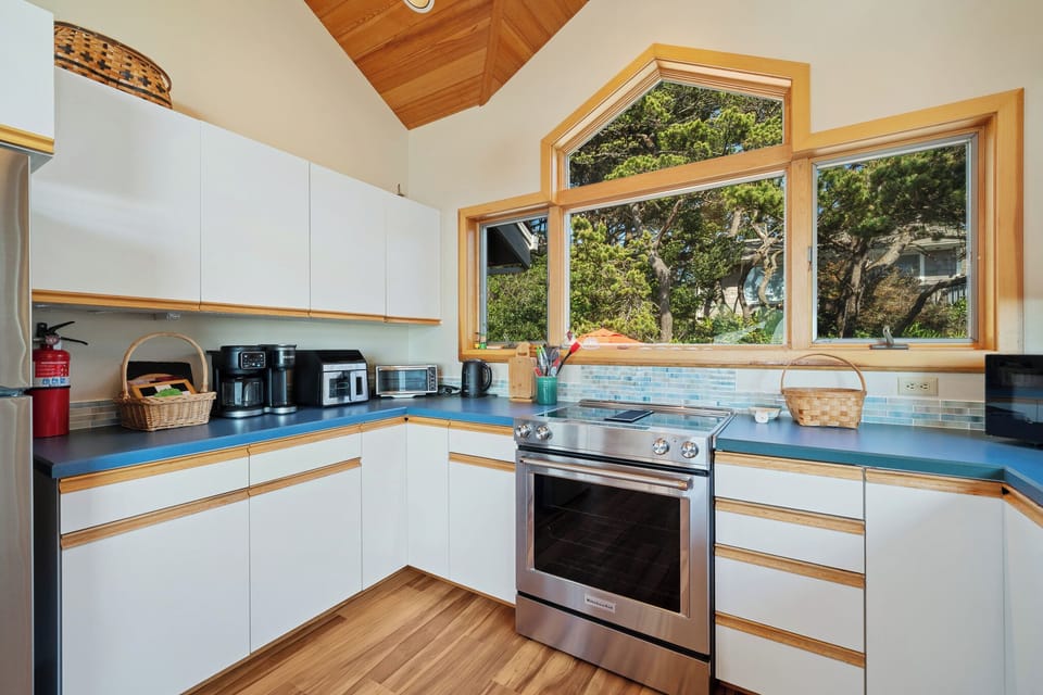 Your fully equipped kitchen awaits with sleek appliances, ample counter space, and beautiful garden views through large windows that fill the room with natural light.