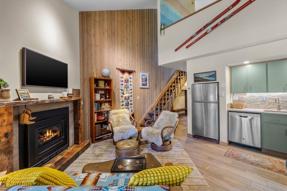 Cozy up by the fireplace in your spacious living area, where rustic wood accents and mountain charm create the perfect retreat after a day on the slopes.