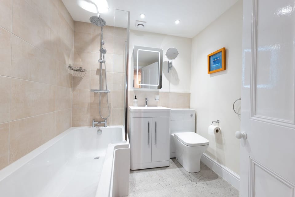 Main bathroom with a bath/shower combo and rainfall shower head