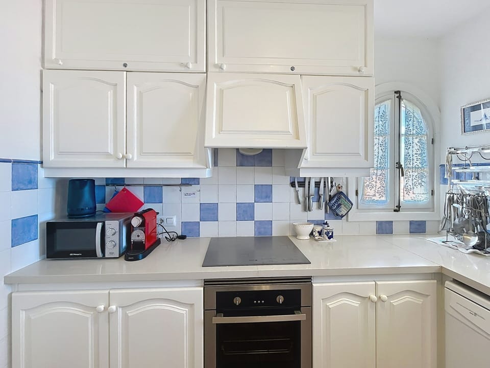 Fully equipped kitchen with hob, oven, Nespresso machine, microwave, and electric kettle.