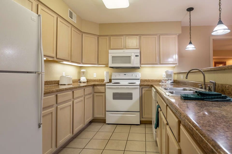 Well-appointed kitchen with white appliances and tile flooring.