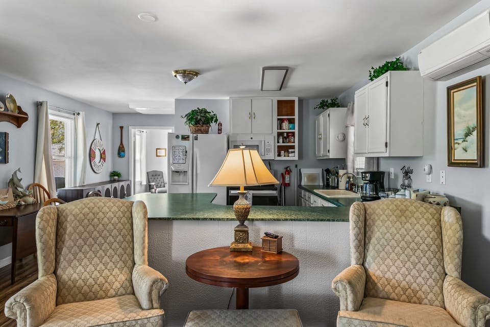 Living space with two plush armchairs and warm wall tones — a quiet spot to decompress after a day on the Gulf