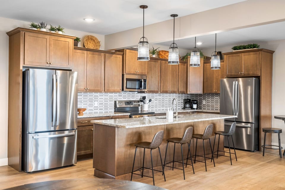 Discover your perfect getaway in this stunning, modern kitchen! Featuring sleek stainless steel appliances, warm wood cabinetry, and stylish pendant lighting, this space is designed for both cooking and entertaining. 