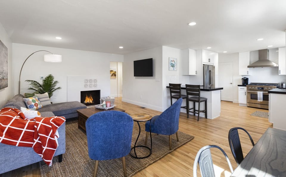 Bright, open living room with cozy fireplace, stylish seating, and Smart TV.