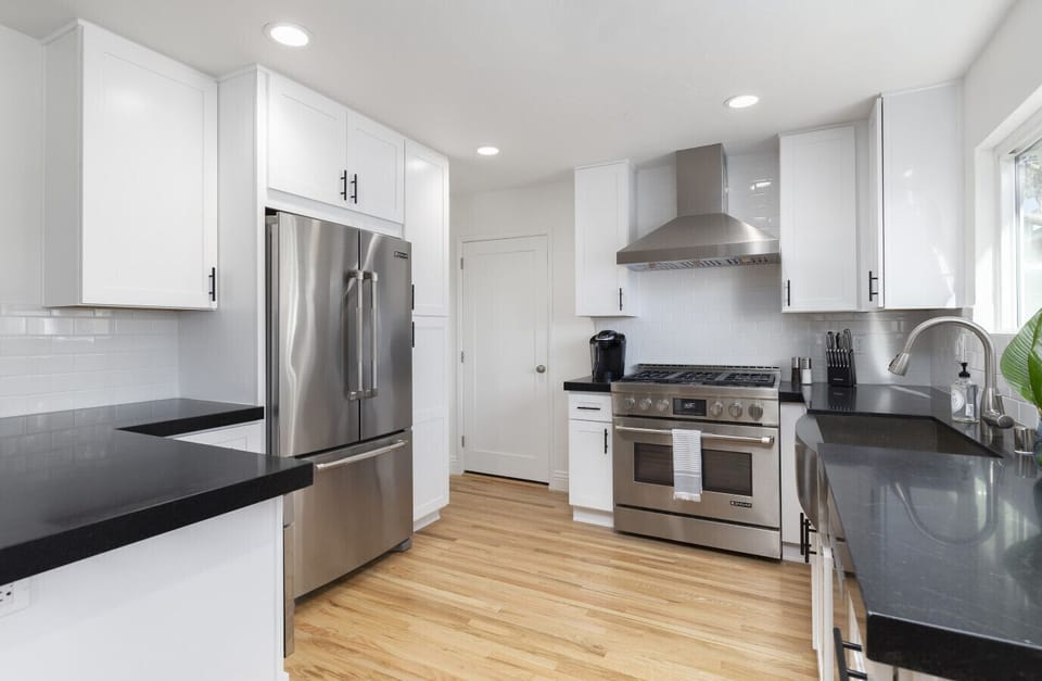 Fully stocked gourmet kitchen with stainless steel appliances, gas range, and quartz countertops.