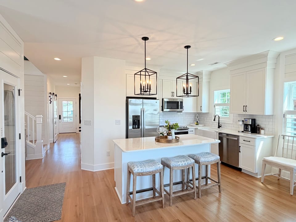 An upscale kitchen features quartz countertops & stainless steel appliances.
