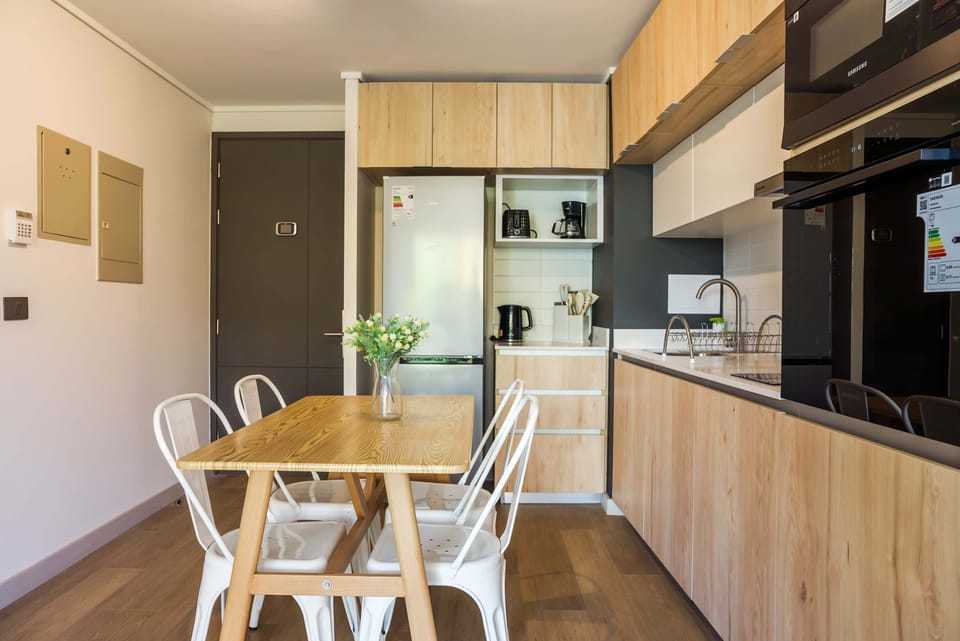 Modern kitchen with sleek appliances and a cozy dining area, perfect for enjoying meals in style.