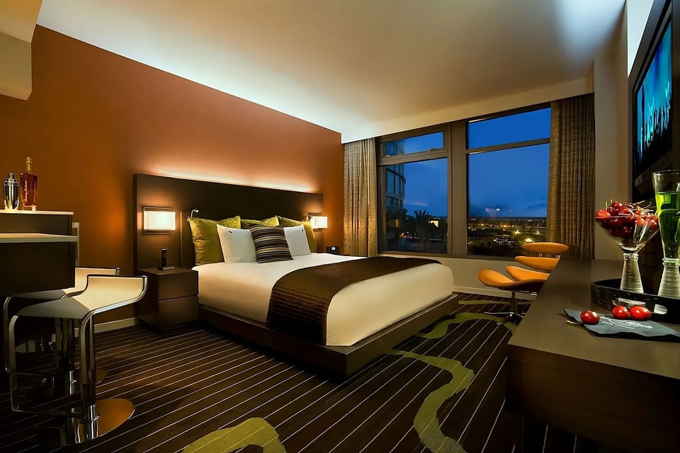 Unwind in a designer king bed with sparkling city views.