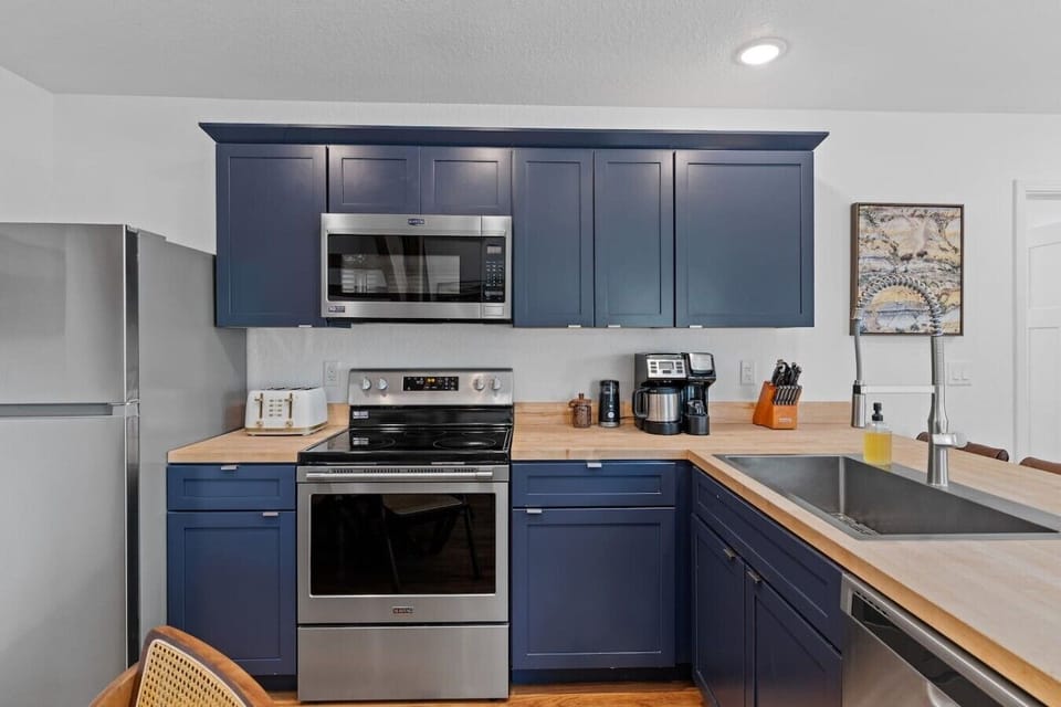 The kitchen features a full-size stove and oven, perfect for preparing home-cooked meals, along with a microwave, toaster and dishwasher.