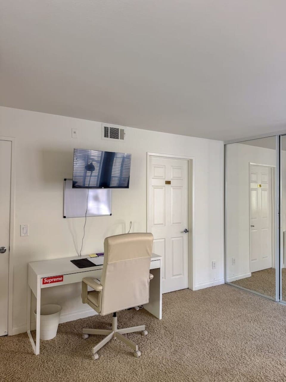 Comfortable bedroom with wall-mounted smart TV and easy closet access, a practical and relaxing space for longer stays.