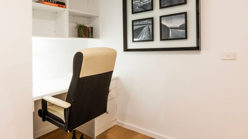 Comfortable bedroom setup featuring a dedicated desk and chair, along with a relaxed sitting area for reading, working, or unwinding during your stay.