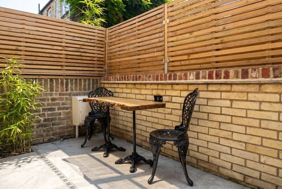 A private enclosed courtyard with cast-iron bistro chairs for a quiet morning coffee.