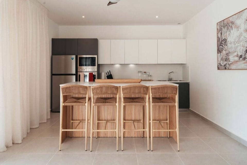 Fully equipped kitchen with a spacious island and four bar stools, perfect for casual meals or morning coffee.