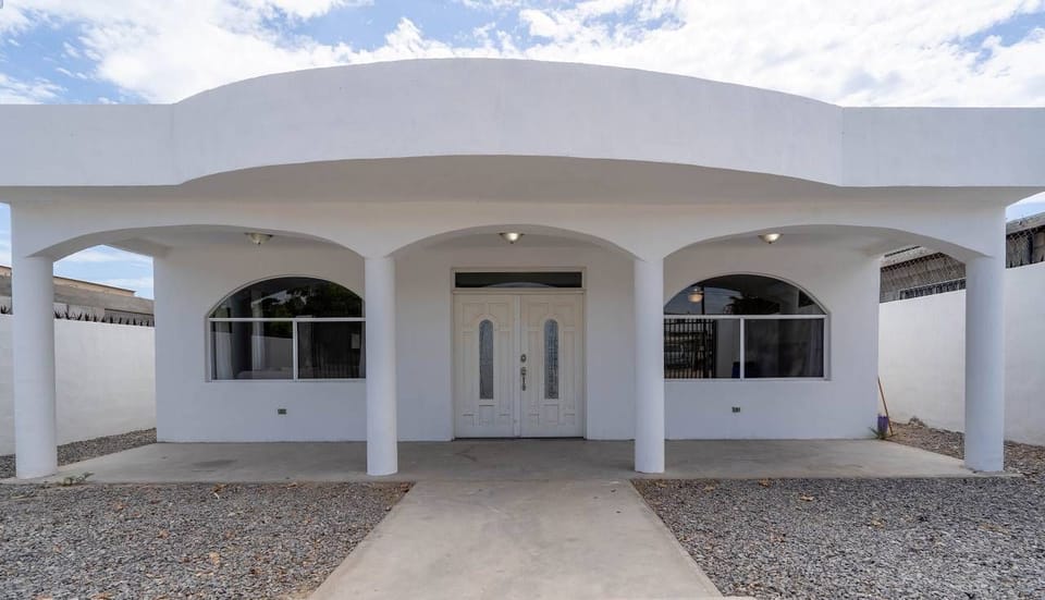 Large iron gate surrounds the property with a rock garden in the front yard and a shady lounge area by the front door. Newly built in 2020, this 3-bedroom, 2-bath home features a private pool and outdoor BBQ
