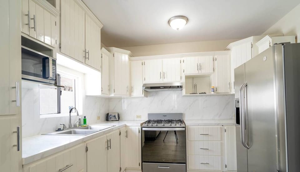 Custom cabinets, granite countertops, two large sinks, and high-end appliances. Includes toaster, coffee maker, blender, and fully stocked utensils
