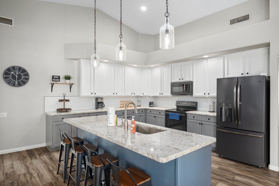 The spacious gourmet kitchen features granite countertops, modern appliances, and a large island with seating—perfect for gathering, cooking, and entertaining during your stay.