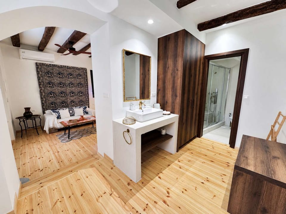 Bright bedroom with a comfortable bed, exposed wooden beams, and wooden furnishings, creating a warm and authentic atmosphere.