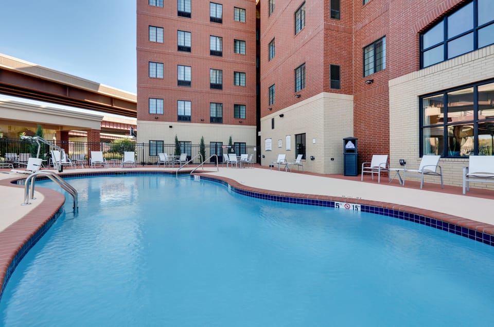 Sparkling outdoor pool surrounded by comfortable lounge chairs and seating.