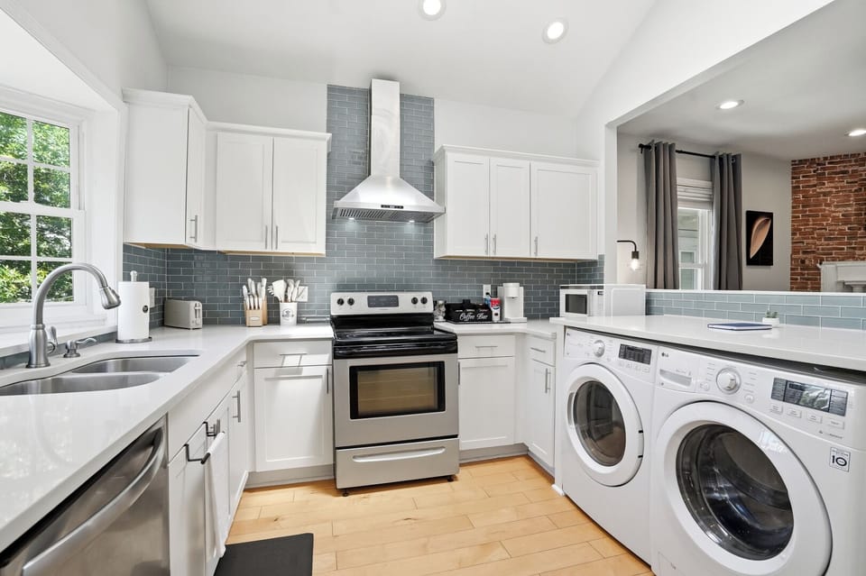 Cook and entertain with ease in this open-concept kitchen featuring stainless steel appliances, plenty of space, and direct views of the living room TV so you can keep up with your favorite shows while preparing meals!