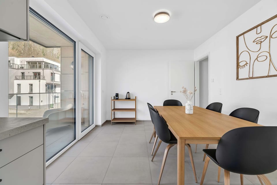 Dining and workspace area next to large windows, ideal for work or meals.
