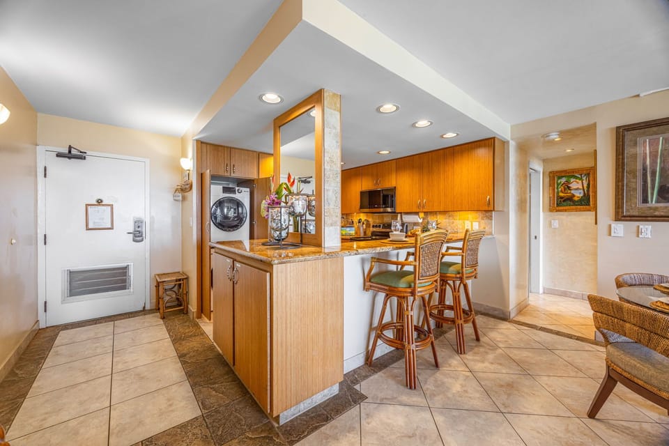 Kitchen & Entry - View of the front entrance, convenient in-home washer and dryer, and fully equipped kitchen with counter seating 