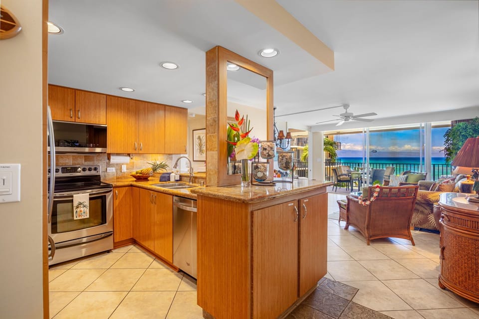 Kitchen - Fully equipped kitchen featuring stainless steel appliances, ample cabinetry, and an open layout offering beautiful ocean views extending through the living area 
