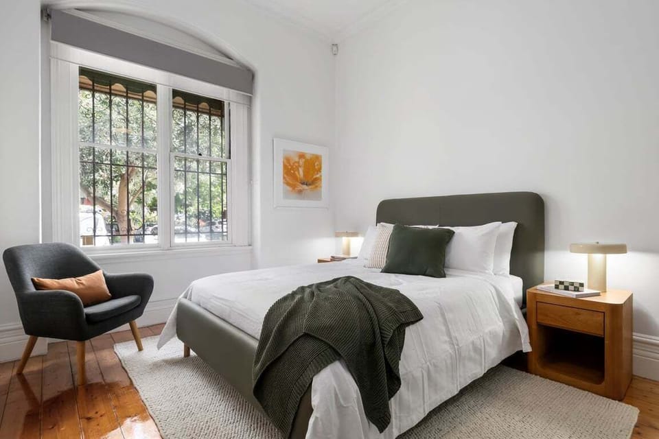 Spacious bedroom featuring large windows and a cozy, inviting feel.