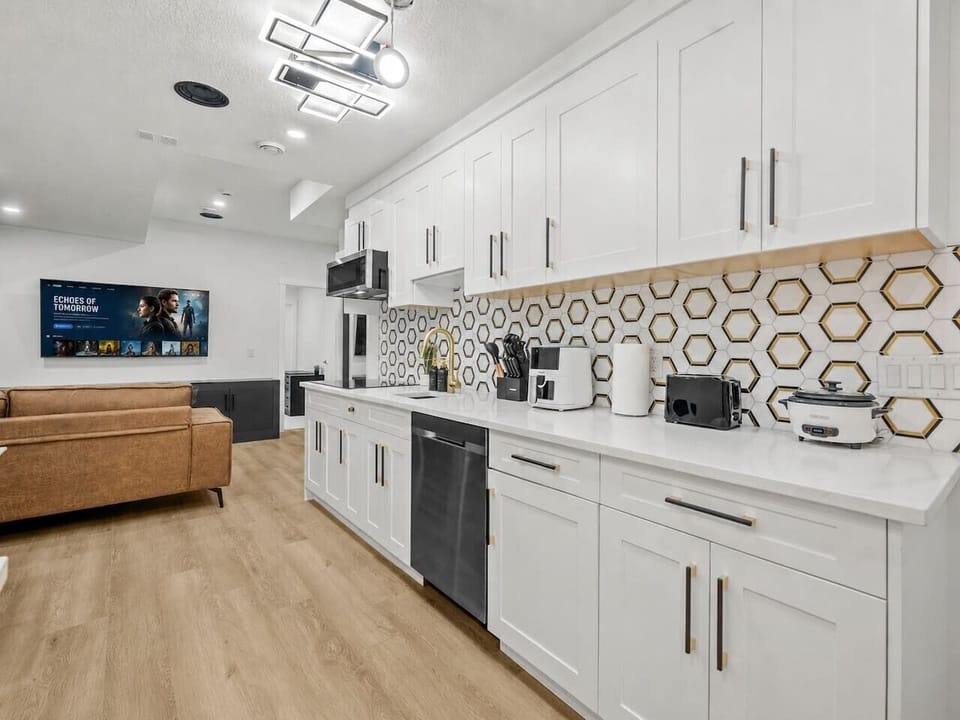 Well-equipped kitchen with white cabinetry and comfortable seating area