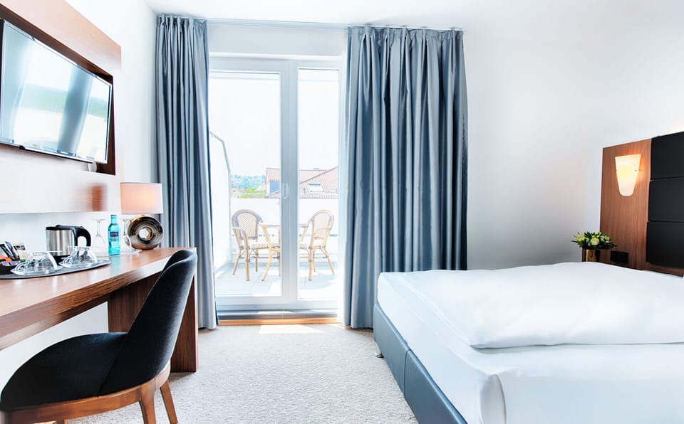 Unwind in a bright bedroom with breezy balcony views.