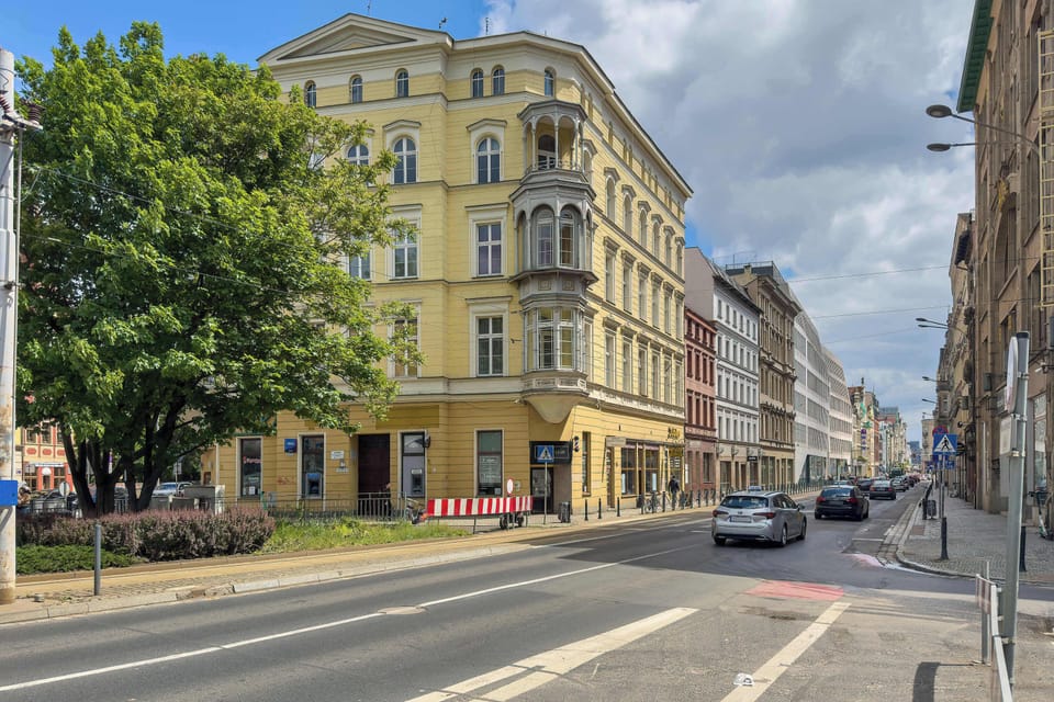 A wide urban view featuring elegant historic buildings and tree-lined streets.