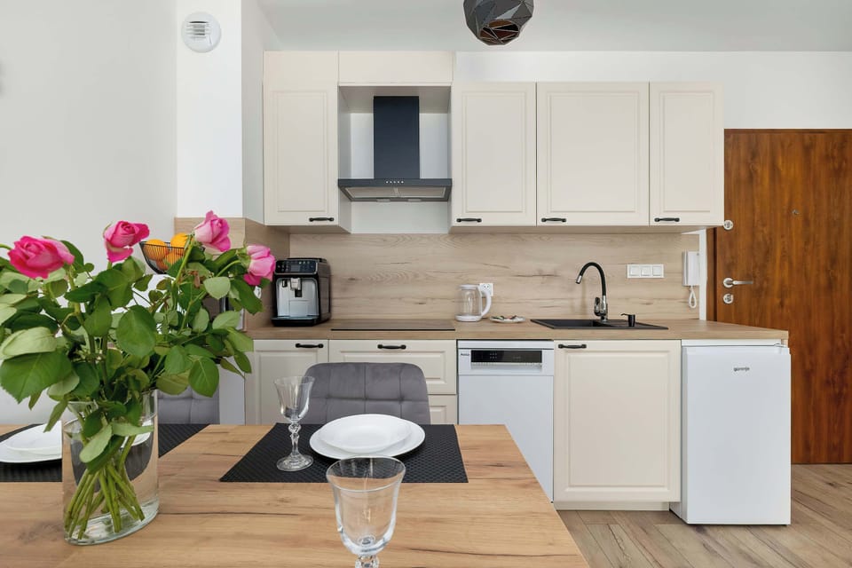 Dining area connected to modern kitchen with fresh flowers