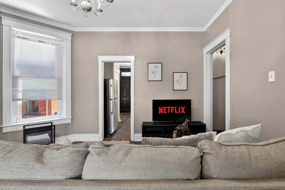 Living Room: Spacious living room featuring a cozy sofa, hardwood floors, and curated decor — the perfect spot to unwind after a long day of travel