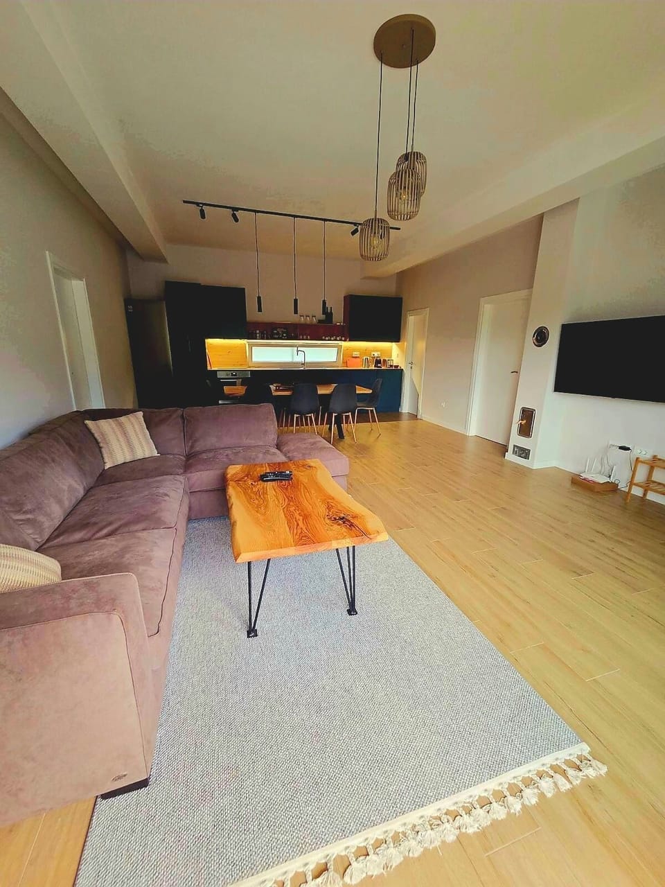interior, indoor, couch, refrigerator, living area, television, kitchen visible