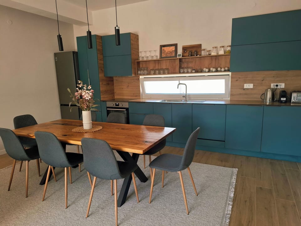 kitchen visible, indoor dining, indoor, coffee and or coffee maker, oven, refrigerator, stovetop, dining table