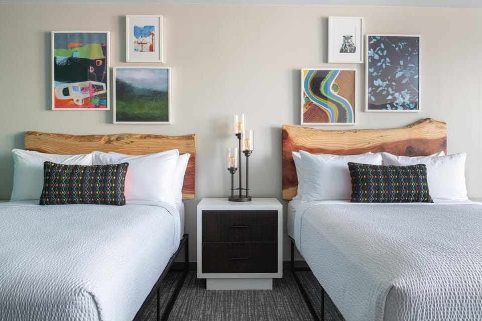 Drift off beneath curated art and warm wood headboards.