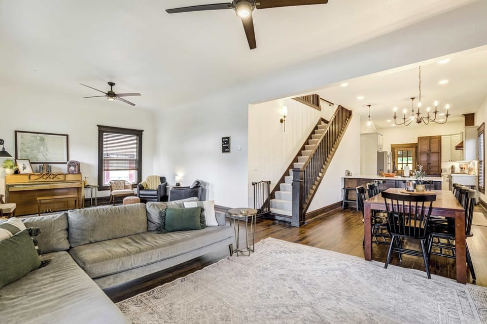 The main level flows seamlessly from the living room to the dining area and kitchen beyond, with hardwood floors, high ceilings, and an open layout that keeps the whole group connected no matter where you are.