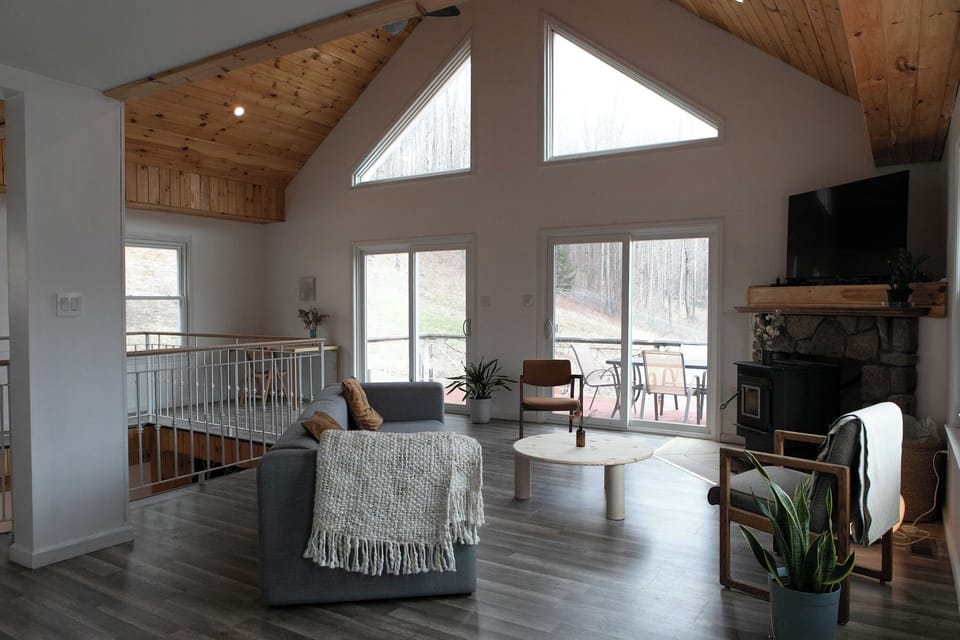 Bright upper-level living space with vaulted wood ceilings and deck access.