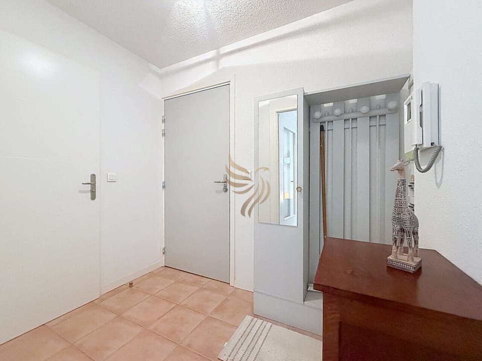 Poussez la porte : un petit hall lumineux où poser vos clés sur la console en bois. Le miroir et les patères prêtent à un départ rapide, la girafe rappelle les voyages passés, un accueil chaleureux avant l`exploration.