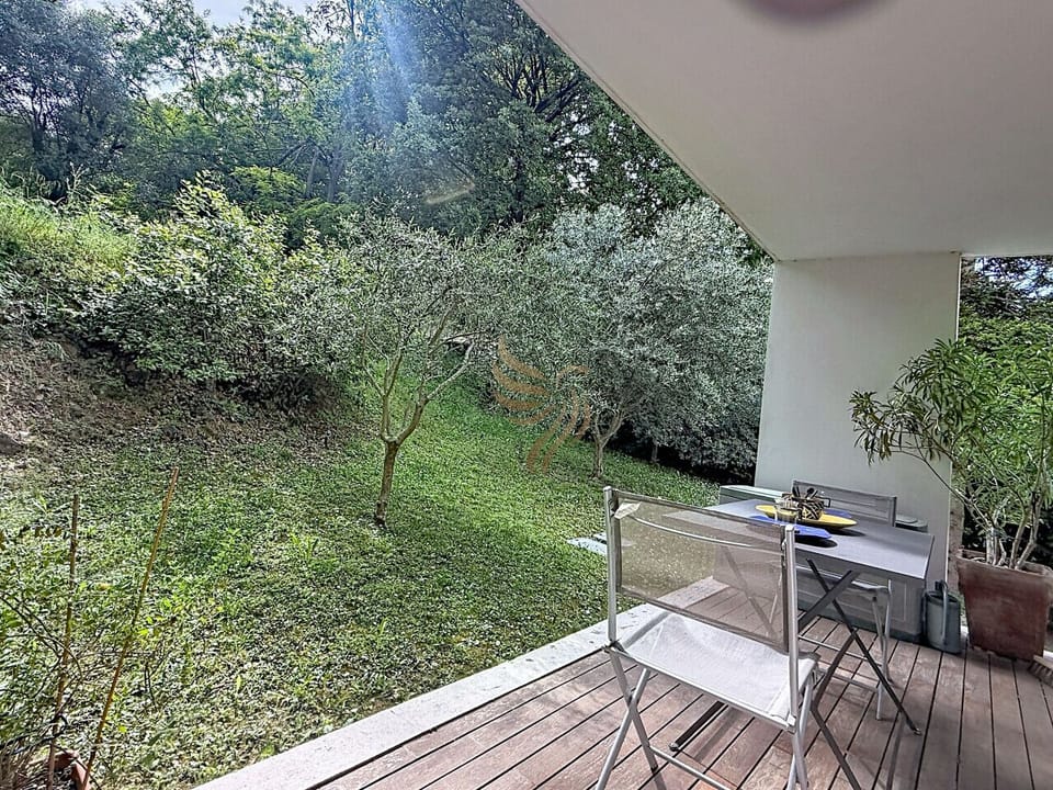 Au réveil, installez-vous sur la terrasse en bois: un café fumant à deux, la vue sur les oliviers et la pelouse en pente, un coin intime où la verdure invite à la détente.